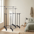 Clothes racks styled in an ivory and sage bedroom